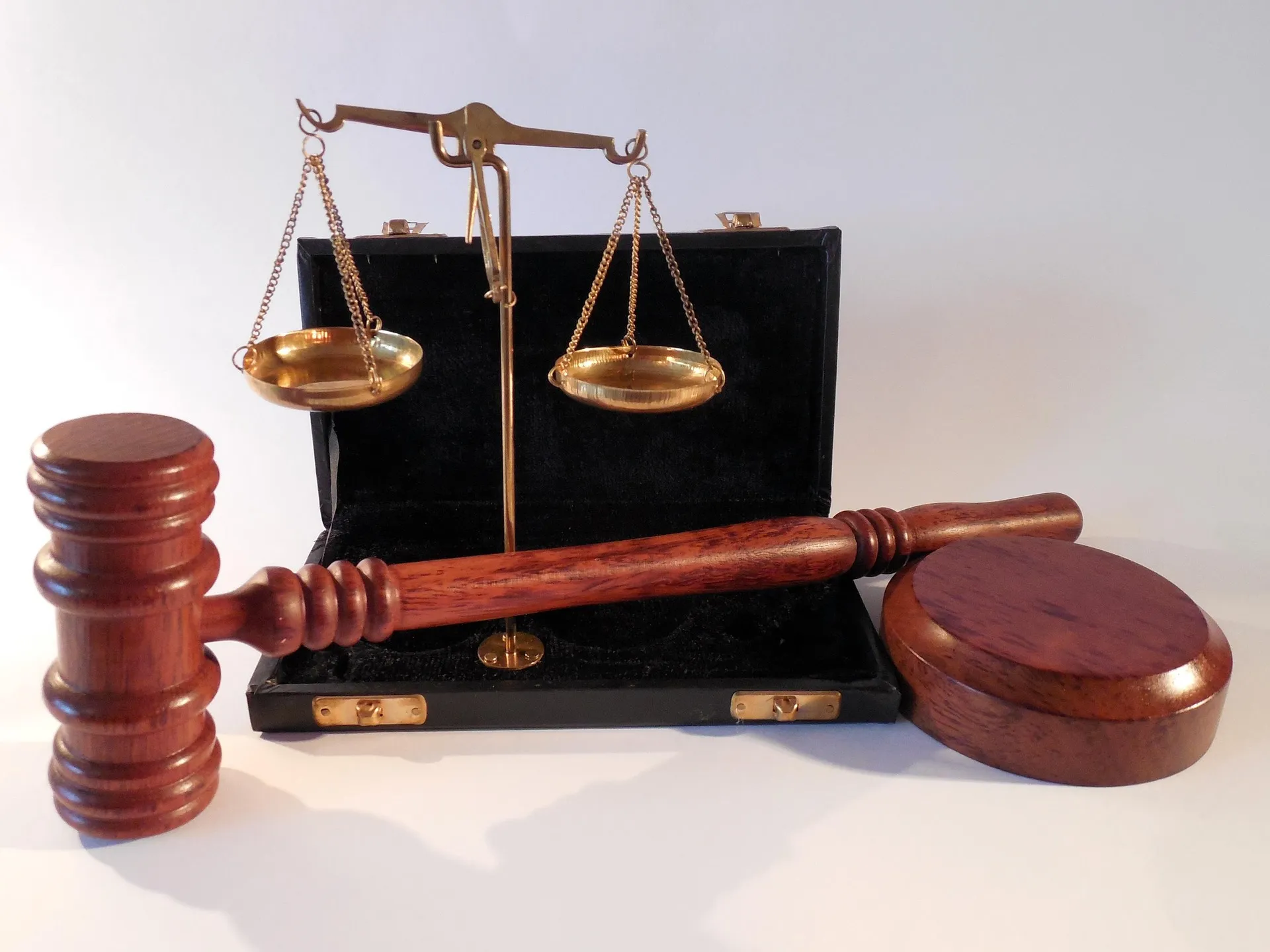 A judge's gavel and a set of brass scales, representing tax and legal rules